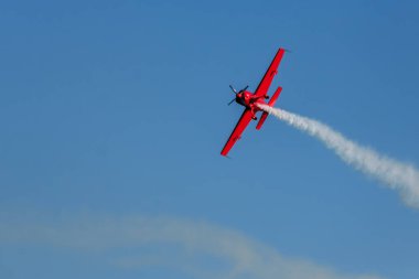 Kırmızı dublör akrobatik uçak mavi gökyüzünde dublörlük yapıyor. Hız kavramı, zorluk, kesinlik, risk