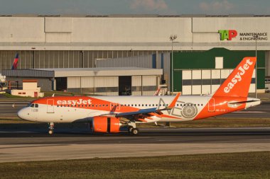 Lisbon, Portugal - September 11, 2023: easyJet Airbus A320-251N passenger plane taxi on runway in Humberto Delgado Airport in Lisbon on sunset clipart