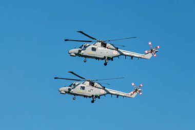 Oeiras, Portugal - September 30, 2023: Two Westland Lynx military helicopters of Portuguese Navy demo flight at Oeiras Air Show clipart