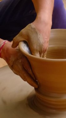 Çömlekçi - çömlekçinin becerikli ıslak elleri çömlekçi çarkındaki çamuru şekillendiriyor. Esrar, vazo fırlatma. Geleneksel el işi Hint kâsesi, kavanoz, esrar, sürahi üretiyor. Shilpagram, Udaipur, Rajasthan, Hindistan