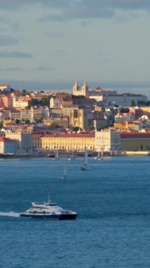 Almada 'dan Tagus nehrinin üzerindeki Lizbon manzarası gün batımında feribot ve yat tekneleriyle. Lizbon, Portekiz. Kamera tavası