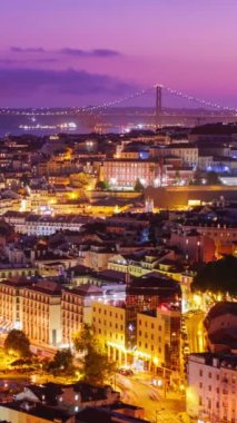 Lizbon 'un ünlü manzarası Miradouro da Senhora do Monte turist bakış açısıyla Alfama eski şehir bölgesi, 25 Nisan Köprüsü, akşam alacakaranlığı. Lizbon, Portekiz. Kamera pan efekti