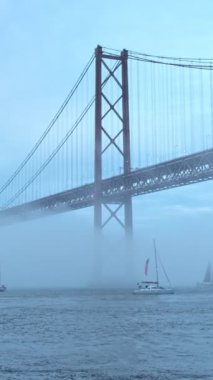 25 de Abril Köprüsü 'nün Lizbon' un ünlü turistik beldesi, Lisboa ve Almada 'yı yoğun sis bulutu altında, altından geçen yat tekneleriyle bağlıyor. Lizbon, Portekiz