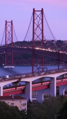 Lizbon manzarası Miradouro do Bairro do Alvito turist bakış açısı Tagus nehri, 25 Nisan Köprüsü trafiği ve akşam alacakaranlığında Kral İsa heykeli. Lizbon, Portekiz