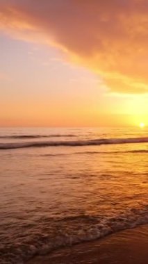 Atlantik Okyanusu 'nun batışında, insanların siluetleri dalgalanan dalgalar ile Fonte da Telha plajında, Costa da Caparica, Portekiz