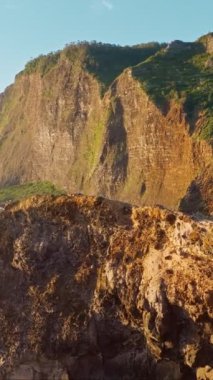 Madeira kayalıkları kıyı şeridi manzarası gündoğumunda, Guindaste bakış açısı, Madeira Adası, Portekiz. Eğik vinç görüntüyü gösterir