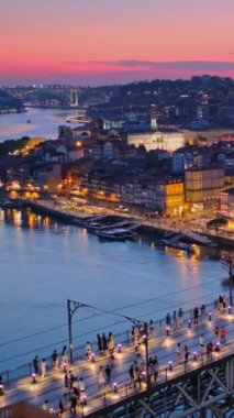 Porto şehri ve Douro nehri manzarası ve Dom Luis köprüsü ünlü turist bakış açısı Miradouro da Serra do Pilar 'dan metro tramvayı ile akşam alacakaranlığı. Porto, Vila Nova de Gaia, Portekiz