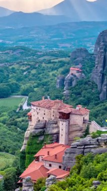 Yunanistan 'ın ünlü turizm beldesi Meteora' da, Rousanou manastırı ve St. Nicholas Anapavsa Manastırı 'nın üzerindeki güneş ışınlarıyla gün batımı zamanı. Uzaklaştırma efekti