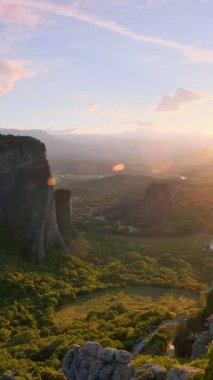 Yunanistan 'ın ünlü Yunan turizm beldesi Meteora' da, Rousanou manastırı ve St. Nicholas Anapavsa Manastırı 'nın üzerinde gün batımı güneş ışınları ve merceklerle parlıyor. Yatay kamera tavası