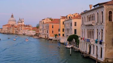 Venedik, İtalya - 19 Temmuz 2019: Günbatımında Ponte dellAccademia Köprüsü 'nden Santa Maria della Salute kilisesine giden gondol ve vaporetto tekneli Venedik Büyük Kanalı manzarası. Kamera tavası