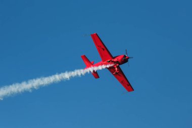 Kırmızı dublör akrobatik uçak mavi gökyüzünde dublörlük yapıyor. Hız kavramı, zorluk, kesinlik, risk