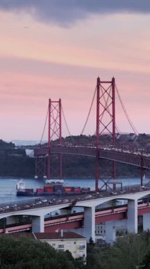 Lizbon manzarası Miradouro do Bairro do Alvito turist bakış açısı Tagus nehri, 25 Nisan Köprüsü trafiği ve gün batımında Kral İsa heykeli. Lizbon, Portekiz. Kamera tavası