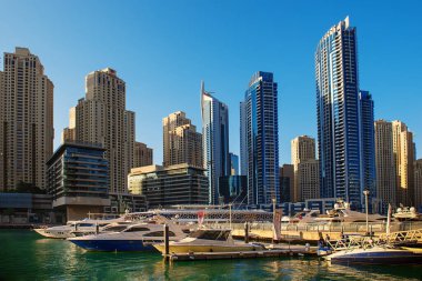 Gün batımından önce Dubai Marina 'da gökdelenler, botlar ve deniz yansımaları, Birleşik Arap Emirlikleri