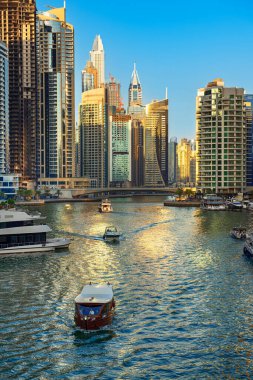 Gün batımından önce Dubai Marina 'da gökdelenler, botlar ve deniz yansımaları, Birleşik Arap Emirlikleri