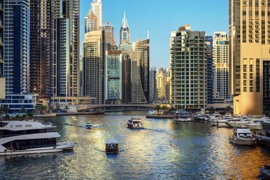 Gün batımından önce Dubai Marina 'da gökdelenler, botlar ve deniz yansımaları, Birleşik Arap Emirlikleri