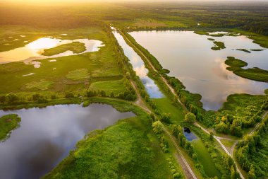 Kırsal yaz günbatımı manzarası nehir, göller, bataklık ve güneş ışığı, doğal arka plan, hava manzarası