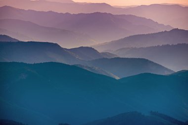 Karpat Dağları yaz günbatımı manzarası soyut dağ tepelerinin mavi renkleriyle gradyanı, doğal seyahat arka planı