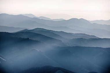 Karpat Dağları yaz günbatımı manzarası soyut dağ tepelerinin mavi renkleriyle gradyanı, doğal seyahat arka planı