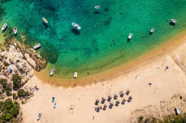 Soyut deniz sahili geçmişi. Yaratıcı minimum plaj konsepti. Mavi su ve şemsiyeli yaz tatili düzeni. Düz yatıyordu. Yunanistan manzarası