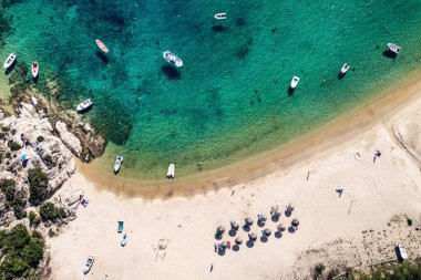 Soyut deniz sahili geçmişi. Yaratıcı minimum plaj konsepti. Mavi su ve şemsiyeli yaz tatili düzeni. Düz yatıyordu. Yunanistan manzarası