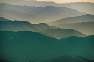 Karpat Dağları yaz günbatımı manzarası soyut dağ tepelerinin mavi renkleriyle gradyanı, doğal seyahat arka planı