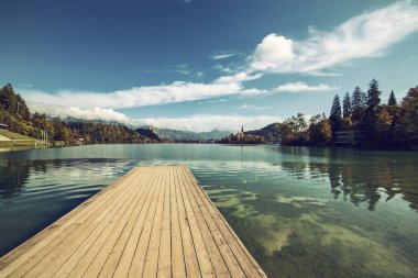 Ahşap iskele Gölü Bled, Slovenya Sonbaharda mavi gökyüzü ve bulutlarla