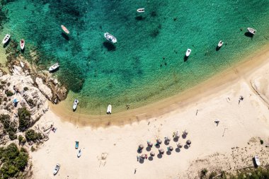 Soyut deniz sahili geçmişi. Yaratıcı minimum plaj konsepti. Mavi su ve şemsiyeli yaz tatili düzeni. Düz yatıyordu. Yunanistan manzarası