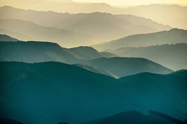 Karpat Dağları yaz günbatımı manzarası soyut dağ tepelerinin mavi renkleriyle gradyanı, doğal seyahat arka planı
