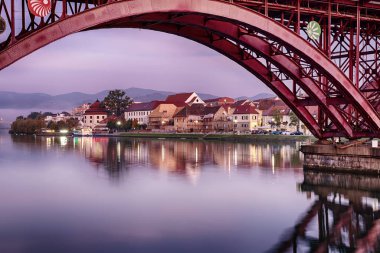 Maribor şehrinin güzel manzarası, Slovenya, gün doğumunda, nehir, köprü ve dramatik gökyüzü. Açık havada dolaşın..