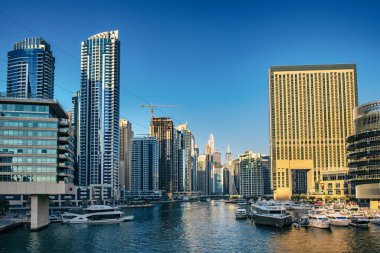 Gün batımından önce Dubai Marina 'da gökdelenler, botlar ve deniz yansımaları, Birleşik Arap Emirlikleri