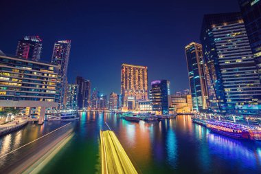 Gece Dubai Limanı 'nda gökdelenler, tekneler ve deniz yansımaları, Birleşik Arap Emirlikleri
