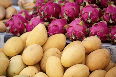 Bir sürü taze sarı mango ve ejderha meyvesi Tayland 'daki markette, tropik mevsimlik egzotik meyveler