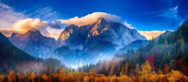 Güneşin doğuşuyla Triglav dağı zirvesi sabah ışığında güzel bulutlarla. Slovenya, Triglav Ulusal Parkı