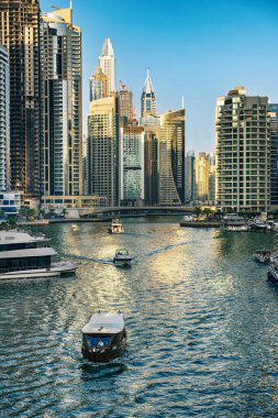 Gün batımından önce Dubai Marina 'da gökdelenler, botlar ve deniz yansımaları, Birleşik Arap Emirlikleri