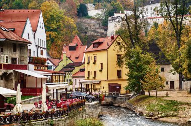 Cesky Krumlov - ünlü bir Czech tarihi güzel kasabası, şehir nehri manzarası ve renkli binalar ve devrilen ağaçlarla dolu güzel bir sonbahar sokağı. Avrupa seyahati geçmişi