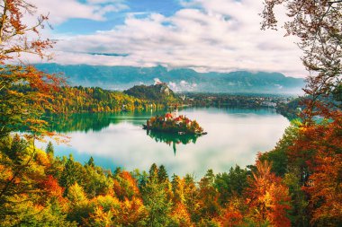 Slovenya, Bled Gölü 'ndeki Varsayım Kilisesi' ne bakın. Sonbaharda renkli ağaçlarla