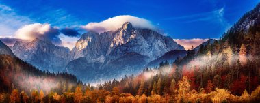 Güneşin doğuşuyla Triglav dağı zirvesi sabah ışığında güzel bulutlarla. Slovenya, Triglav Ulusal Parkı