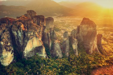 Meteora, Greece. Sandstone rock formations, the Rousanou and Nikolaos monasteries at sunset. Travel destination background
