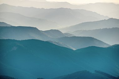 Karpat Dağları yaz günbatımı manzarası soyut dağ tepelerinin mavi renkleriyle gradyanı, doğal seyahat arka planı