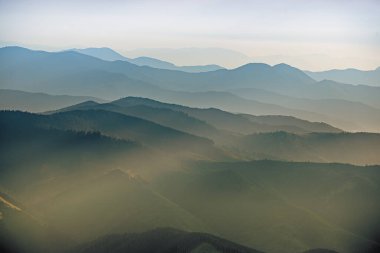 Karpat Dağları yaz günbatımı manzarası soyut dağ tepelerinin mavi renkleriyle gradyanı, doğal seyahat arka planı