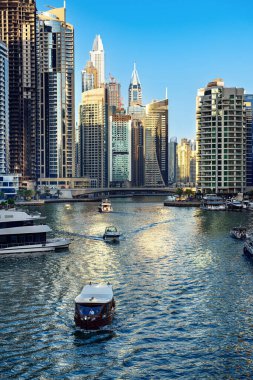 Gün batımından önce Dubai Marina 'da gökdelenler, botlar ve deniz yansımaları, Birleşik Arap Emirlikleri