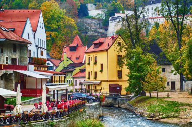 Cesky Krumlov - ünlü bir Czech tarihi güzel kasabası, şehir nehri manzarası ve renkli binalar ve devrilen ağaçlarla dolu güzel bir sonbahar sokağı. Avrupa seyahati geçmişi