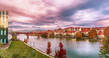 Maribor şehrinin güzel manzarası, Slovenya, güneşin doğuşu, nehir ve dramatik gökyüzü. Açık havada dolaşın..