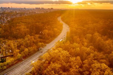 Kırmızı sonbahar ormanı boyunca otoyol manzarası yukarıdan, seyahat macerası konsepti