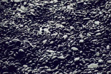 İzlanda 'daki Vik plajında siyah çakıl taşları. Soyut doğal arkaplan