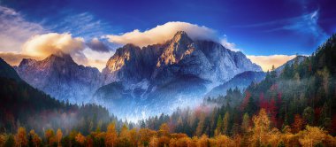 Güneşin doğuşuyla Triglav dağı zirvesi sabah ışığında güzel bulutlarla. Slovenya, Triglav Ulusal Parkı