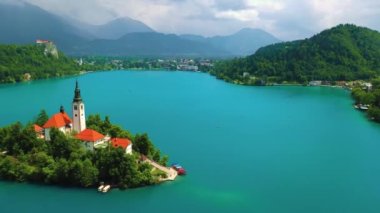 Mary 'nin Varsayımı Kilisesi' nin göl merkezindeki hava manzarası Bled. Slovenya 'daki Bled Gölü' nde küçük bir adada uçmak, canlı mavi su, 4k drone videosu