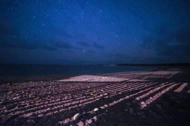 Kıbrıs yaz manzarası gökyüzünde yıldızlar ve sahilde garip gölgeler, doğal yıldızlı seyahat arka planı