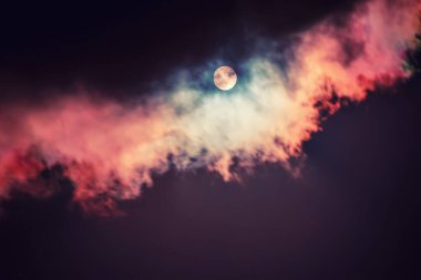 Karanlık gökyüzündeki ay bulutların arasında, doğal soyut arkaplan