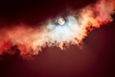 Karanlık gökyüzündeki ay bulutların arasında, doğal soyut arkaplan